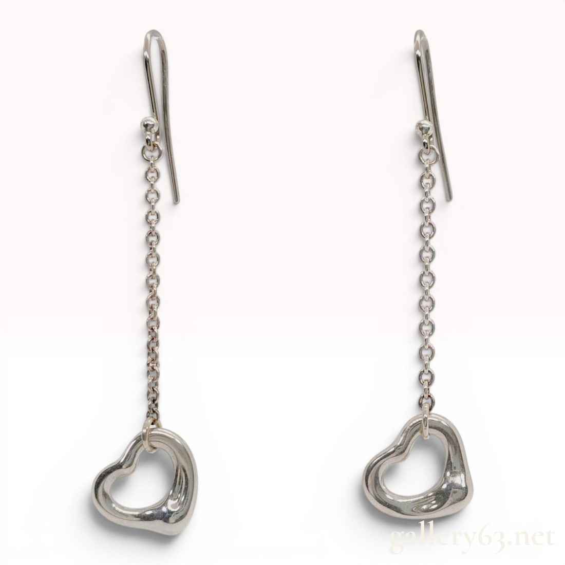 A Pair of Tiffany & Co. Elsa Peretti Sterling Silver Open Heart Drop Earrings: A matched pair of Tiffany & Co. sterling silver drop earrings from the Elsa Peretti Open Heart collection. Each earring features a signature open heart charm suspended from a fine cable link chain