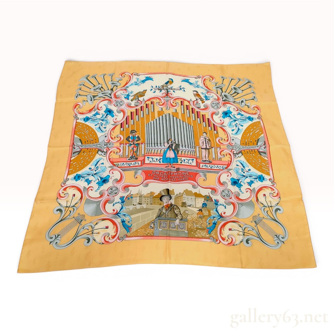 Hermes Silk Jacquard Scarf Orgauphone et Autres Mecaniques: This Hermes silk scarf, titled Orgauphone et Autres Mecaniques, was designed by artist Pierre Peron. The design features a central scene depicting a large mechanical street organ surrounded by automat