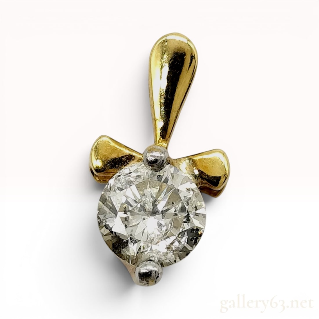 18K Yellow Gold and 0.43 Carat Round Brilliant-Cut Diamond Solitaire Pendant: This pendant features a single round brilliant-cut diamond mounted in a two-tone 18 karat gold setting. The diamond is secured by two white metal prongs positioned atop an 18 karat yellow gold base wi