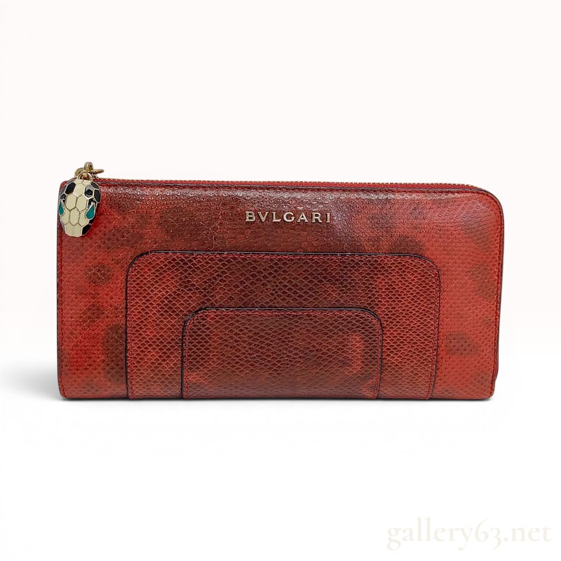 Bulgari Serpenti Forever Red Karung Skin Zip Around Wallet: This long zip-around wallet is part of the iconic Bulgari Serpenti Forever collection. It is crafted from exotic Karung (water snake) skin in a red hue featuring a dark brown or black ombre mottled pa