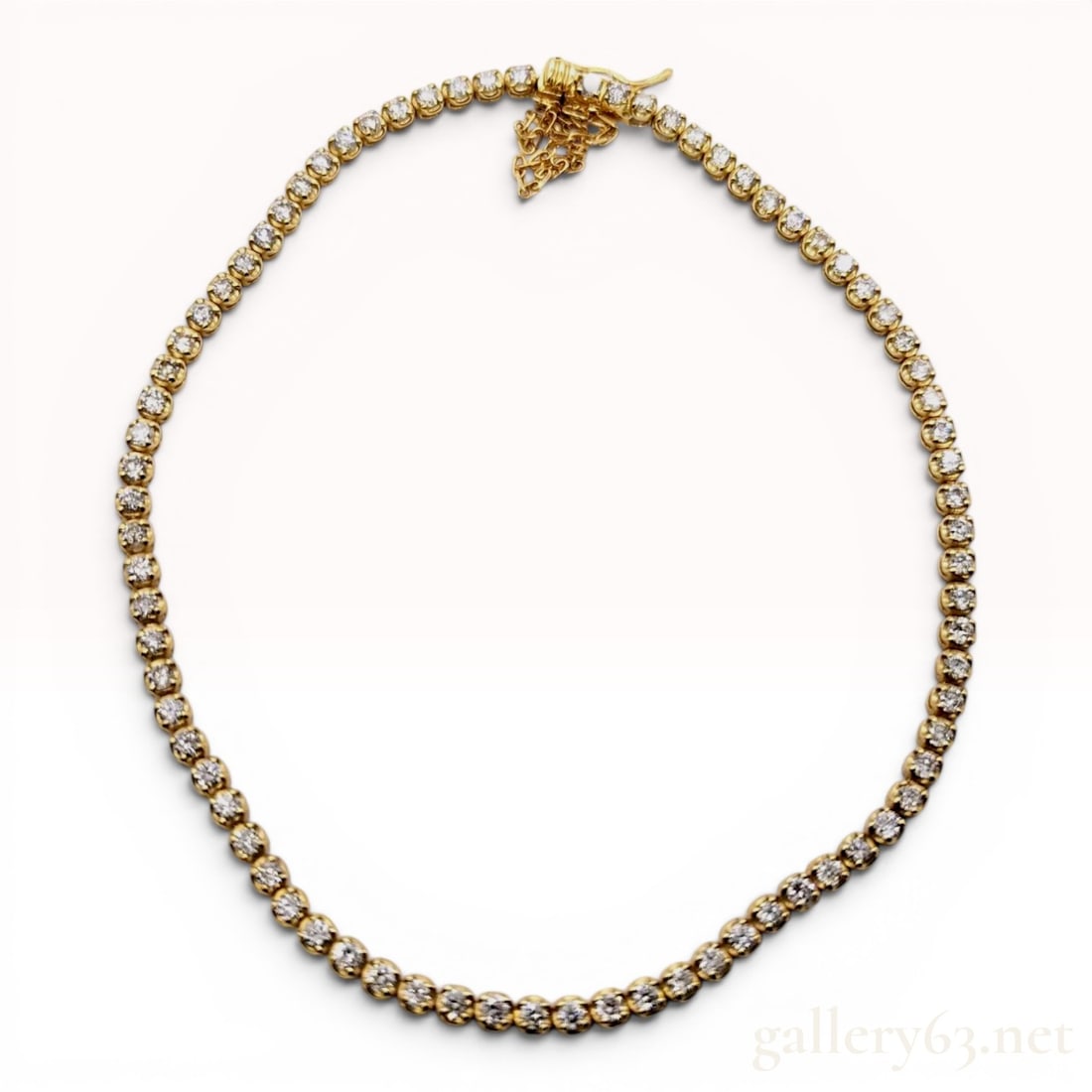 18 Karat Yellow Gold and Diamond Tennis Bracelet: This tennis bracelet is constructed of 18 karat yellow gold and features a continuous line of approximately sixty round brilliant-cut diamonds. Each diamond is individually set within an articulated s