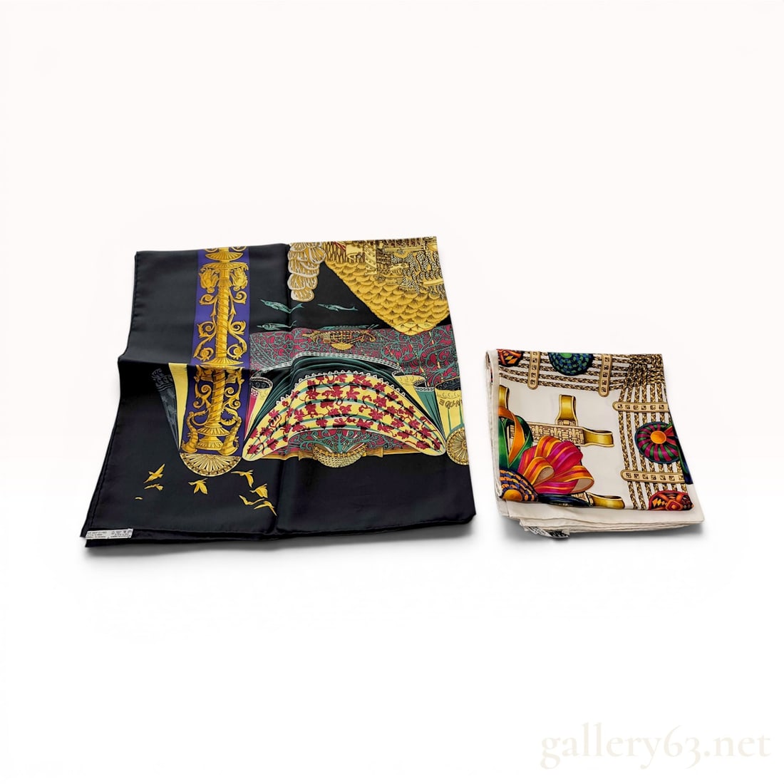 Two Hermes Paris Silk Scarves, Les Rubans du Cheval and L'Atlantide: This lot contains two Hermes Paris 100 percent silk scarves featuring intricate illustrative designs. The first scarf, titled Les Rubans du Cheval and designed by Joachim Metz, features a white ground