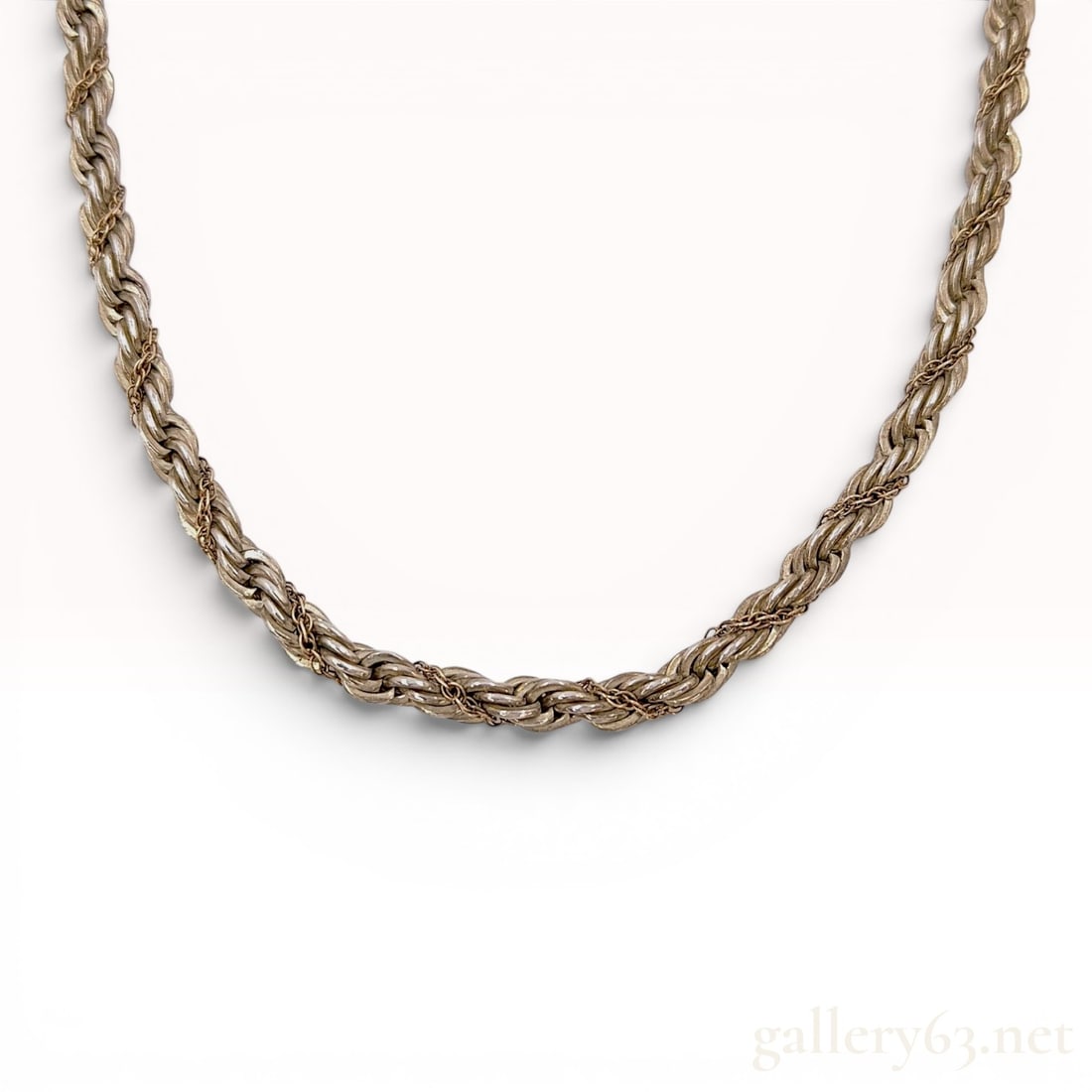 Tiffany & Co. Two-Tone Sterling Silver and 14k Gold Rope Chain Necklace: Tiffany & Co. two-tone rope chain necklace featuring a primary silver-toned rope chain with a secondary 14k gold rope chain intricately wrapped around it. The necklace is secured with a lobster cl