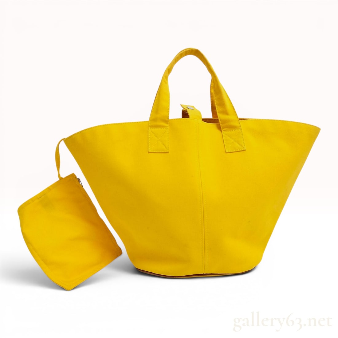 Hermes Panier de Plage Yellow Canvas Tote Bag and Matching Pouch: Hermes Panier de Plage tote bag constructed from heavy-duty yellow canvas with a flared, trapezoidal silhouette. The bag features an oval base reinforced with brown leather piping and two flat canvas 