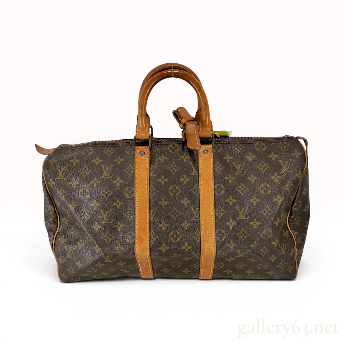 Louis Vuitton Monogram Keepall 50 Travel Bag: A vintage Louis Vuitton Keepall 50 travel bag featuring the house signature brown monogram coated canvas. The bag is trimmed with natural Vachetta leather, including dual rolled top handles, vertical 