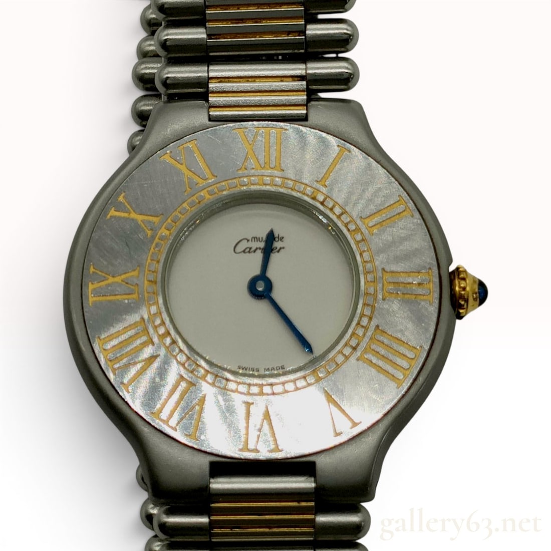 Ladies Must de Cartier 21 Stainless Steel and Gold-Tone Quartz Wristwatch Ref 901063081: This Must de Cartier 21 wristwatch features a stainless steel case with gold-tone accents. The round case houses a two-tone dial with a silver-tone center and blue steel sword-shaped hands. The fixed 
