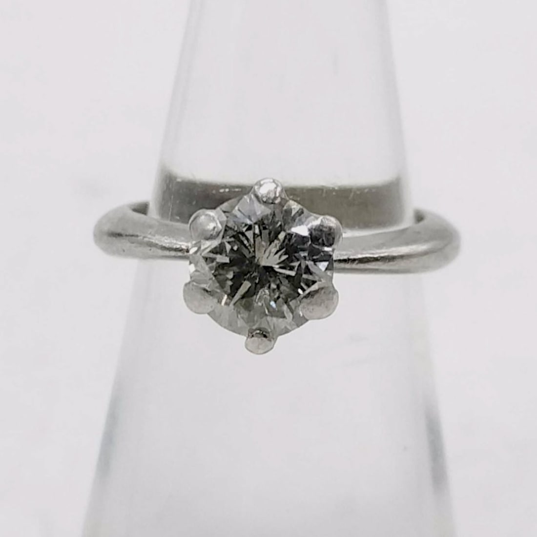 Platinum and `1.17ct Diamond Solitaire Ring: This solitaire engagement-style ring features a single round brilliant-cut center diamond. The gemstone is held in a traditional six-prong setting atop a platinum band. The inner shank is stamped with
