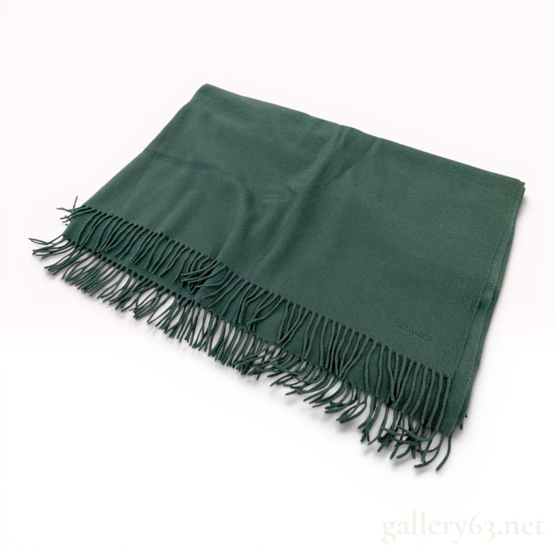 Hermes Forest Green 100% Cashmere Stole/Blanket: A solid forest green Hermes rectangular wrap or blanket crafted from 100% cashmere. The scarf features twisted fringe at both ends and a ton-sur-ton embroidered brand name near one corner reading HERM