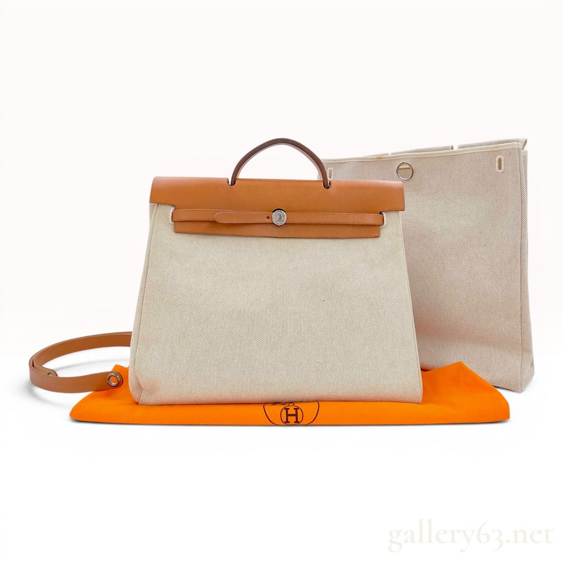 Hermes Toile and Vache Hunter Leather 2-in-1 Herbag 40cm: An Hermes Herbag 2-in-1 handbag featuring an interchangeable design. The set consists of two off-white toile canvas bodies of varying sizes that can be swapped using the leather top assembly. The top 