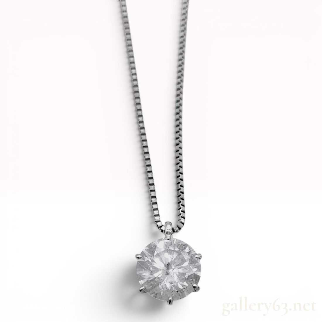 Platinum Round Brilliant-Cut 1.09ct Diamond Solitaire Pendant on Adjustable Box Chain: This platinum solitaire pendant features a single round brilliant-cut diamond. The diamond is secured in a six-prong basket setting. The reverse of the pendant mounting is stamped with 0.9 and Pt900. 