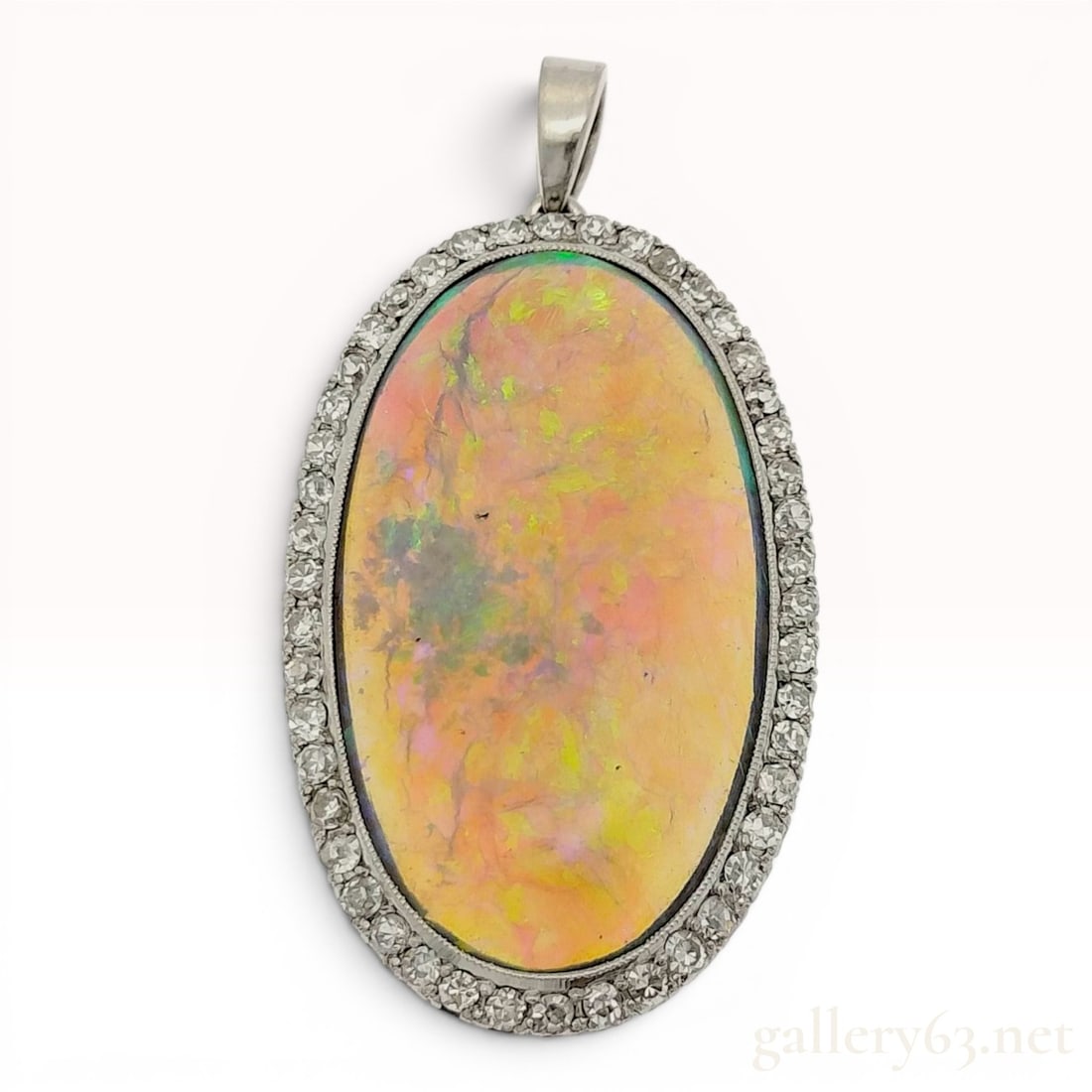 Platinum, Opal, and Diamond Halo Pendant: This pendant is crafted from platinum and features a large central oval cabochon crystal opal. The opal is surrounded by a halo of approximately forty-two round faceted diamonds, which appear to be si