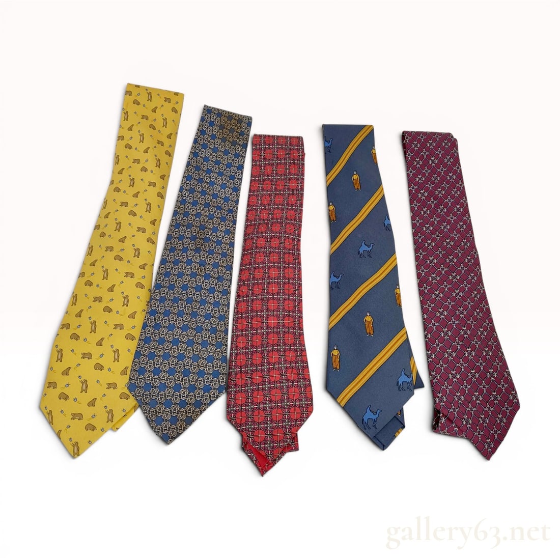 A Lot of Five Hermes Silk Neckties: A lot of five luxury silk neckties by Hermes. Each tie is constructed from 100% silk and was manufactured in France. The assortment features five distinct patterns: a yellow ground with a repeating mo