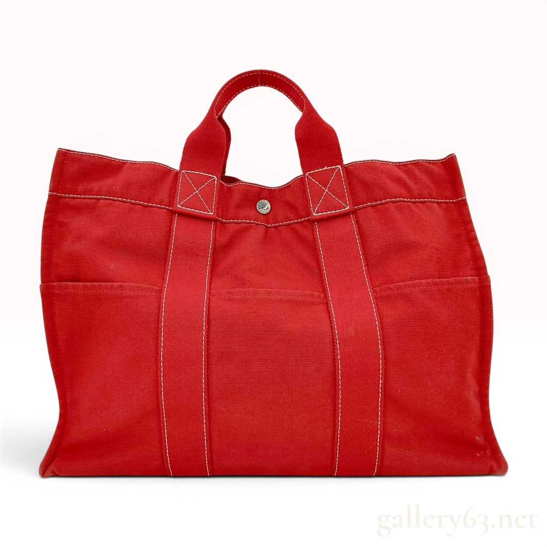 Hermes Fourre-Tout MM Red Canvas Tote Bag: An Hermes Fourre-Tout MM (Moyen Modele) tote bag crafted from durable red cotton canvas featuring white contrast stitching throughout. The exterior is designed with two vertical canvas bands forming t