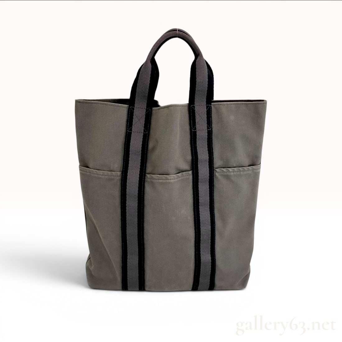 Hermes Fourre-Tout Cabas Canvas Tote Bag: This is a Hermes Fourre-Tout Cabas tote bag, a vertical shopper style crafted from heavyweight gray canvas. The design features integrated textile webbing handles in black and gray stripes that extend