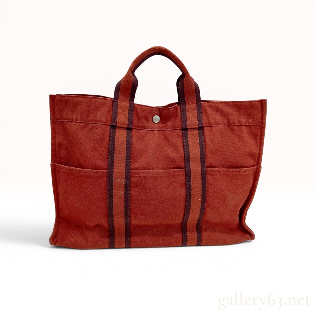 Hermes Fourre-Tout GM Canvas Tote Bag: This Hermes Fourre-Tout GM (Grand Modele) tote bag is constructed from heavyweight cotton canvas in a terracotta shade. The bag features dual top handles and vertical trim made of dark burgundy stripe
