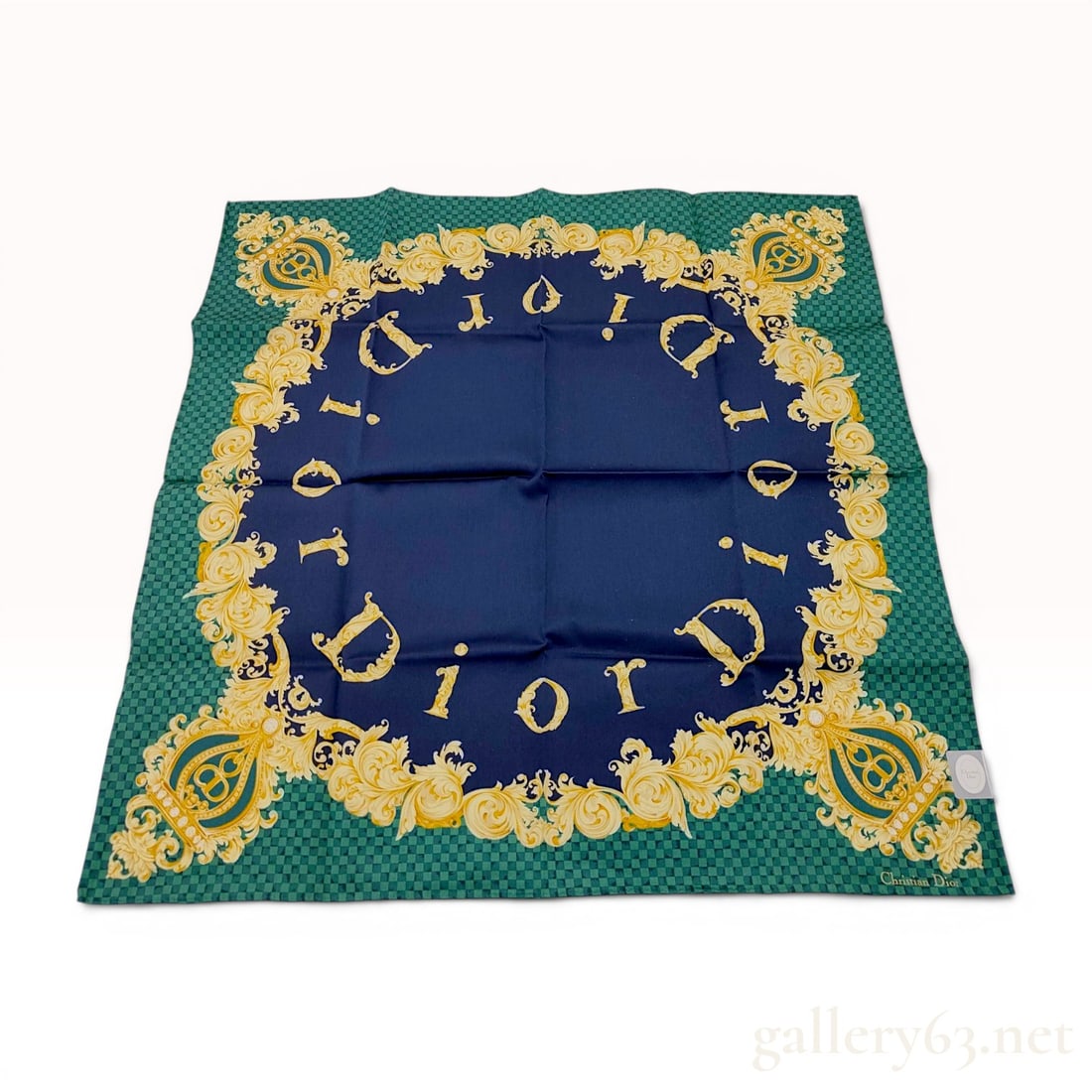 Christian Dior Square Silk Scarf with Baroque CD Monogram Motif and Damier Border: This vintage square silk scarf from Christian Dior features a navy blue central field decorated with an ornate circular arrangement of stylized gold-tone letters spelling DIOR in a baroque-style font.
