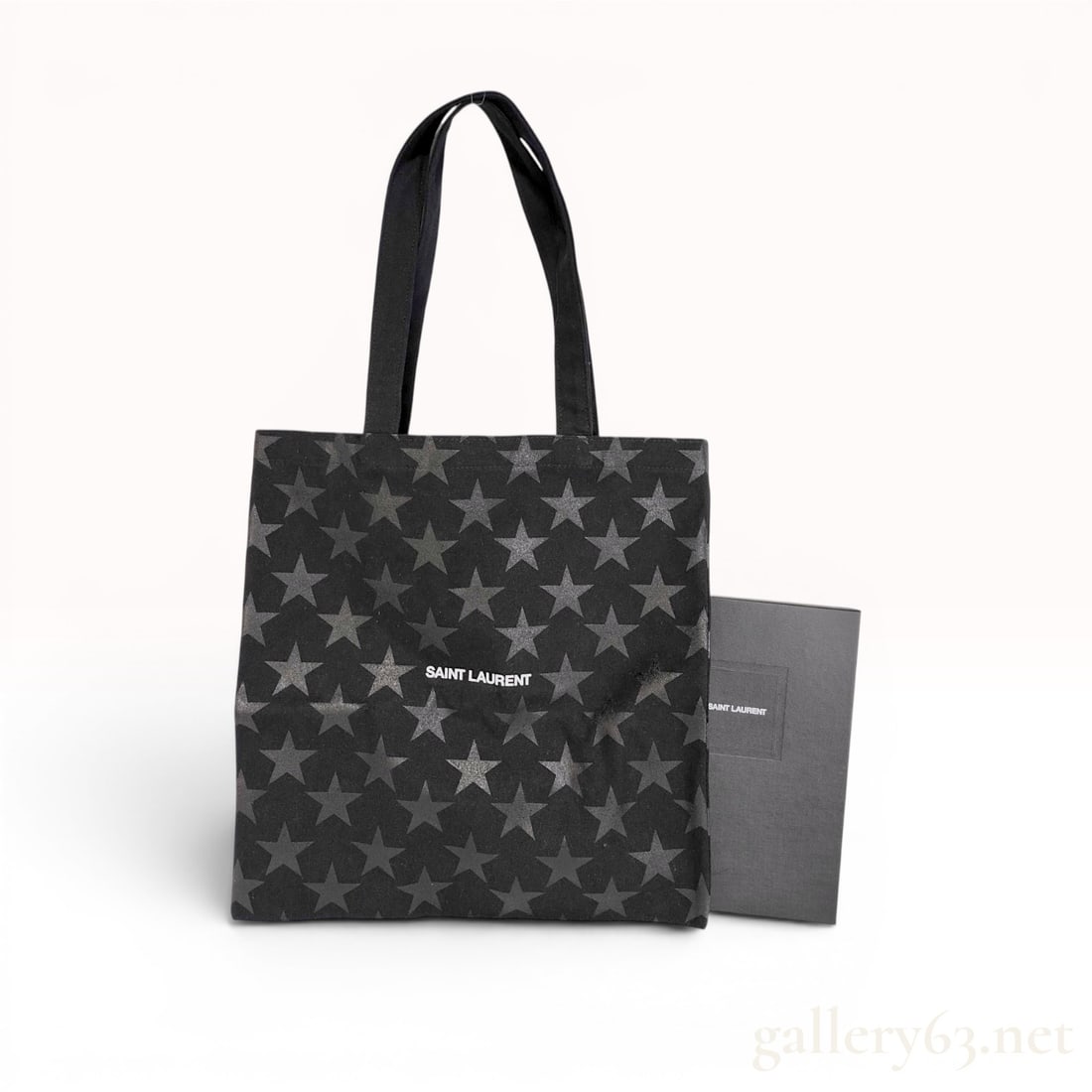 Saint Laurent Black Cotton Star Pattern Tote Bag with Box: This Saint Laurent tote bag is constructed from black cotton canvas featuring an all-over repeating grey star motif. The front of the bag is printed with the brand name SAINT LAURENT in white block le