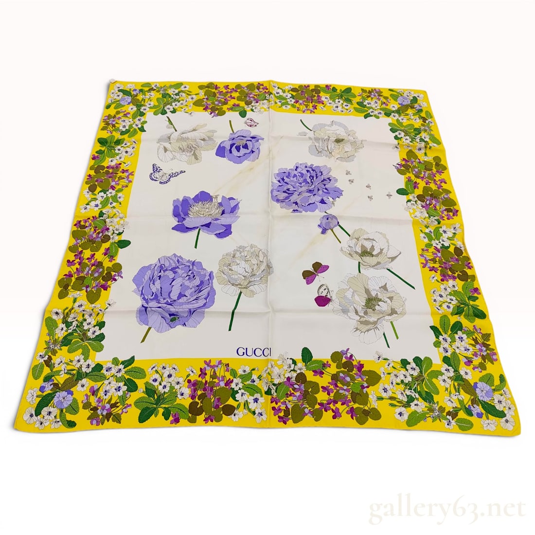 Gucci Flora Pattern Silk Scarf with Yellow Border: A vintage Gucci silk scarf featuring the brand's signature Flora motif. The square scarf is designed with a central white field decorated with large-scale purple and white blossoms and fluttering butt