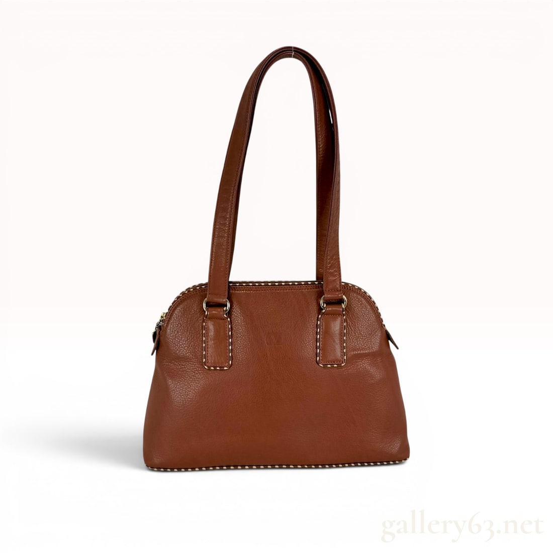 Valentino Garavani Cognac Grained Leather Dome Shoulder Bag with Contrast Whipstitching: A vintage Valentino Garavani dome-style shoulder bag constructed from cognac-toned grained leather. This handbag is detailed with cream-colored contrast whipstitching along the zippered top, the base 