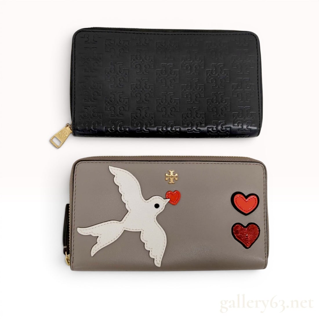 Two Tory Burch Leather Zip-Around Continental Wallets: This lot features two long zip-around continental wallets by Tory Burch. The first wallet is constructed from black leather with an all-over embossed double-T monogram pattern. It features gold-tone