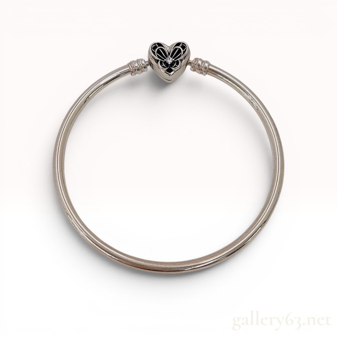 Pandora, Sterling Silver Heart and Butterfly Bangle Bracele: This sterling silver bangle-style charm bracelet is from the Pandora Moments Heart and Butterfly collection. The polished silver-tone band features two threaded sections near the clasp designed to sec