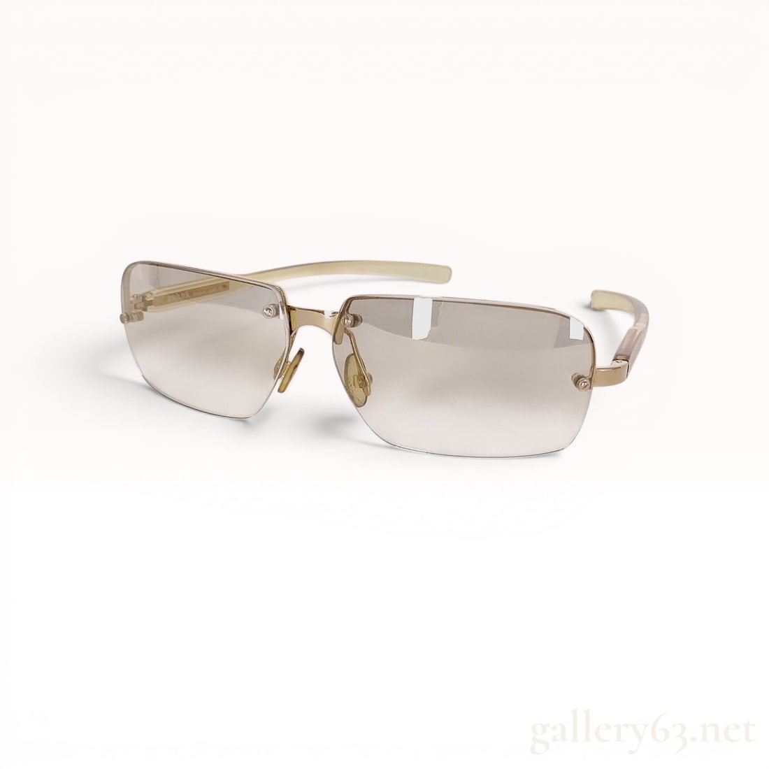 Prada SPR 71C Rimless Rectangular Gradient Sunglasses: A pair of Prada rimless sunglasses, model SPR 71C, featuring a rectangular lens design and a slim gold-toned metal bridge. The lenses are finished with a gradient tint, transitioning from a darker gre