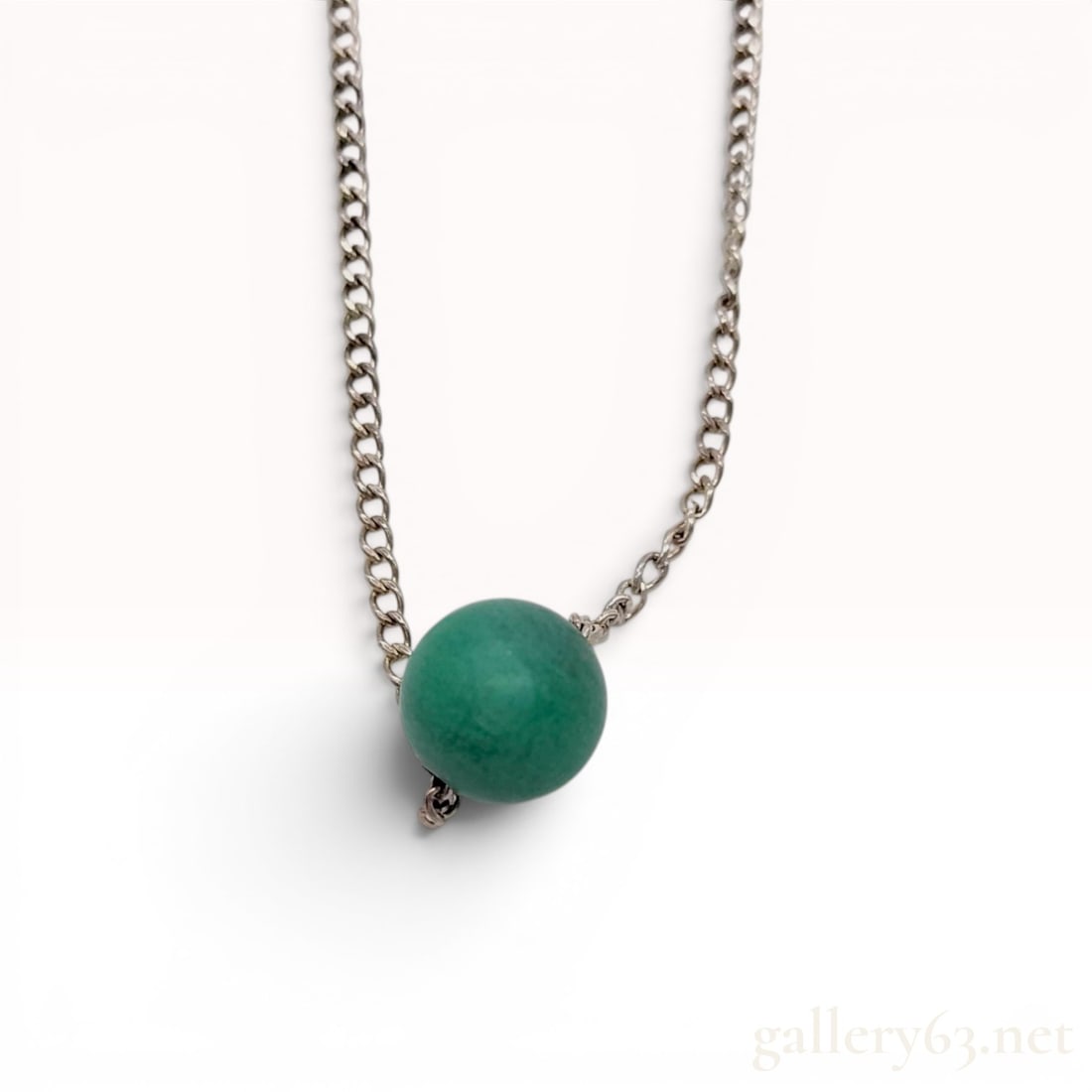 Vintage Tiffany & Co. Sterling Silver and Green Jade Bead Pendant Necklace: This vintage sterling silver pendant necklace features a single spherical green jade bead on a fine curb link chain. The design is characteristic of mid-century minimalist jewelry and includes a circu
