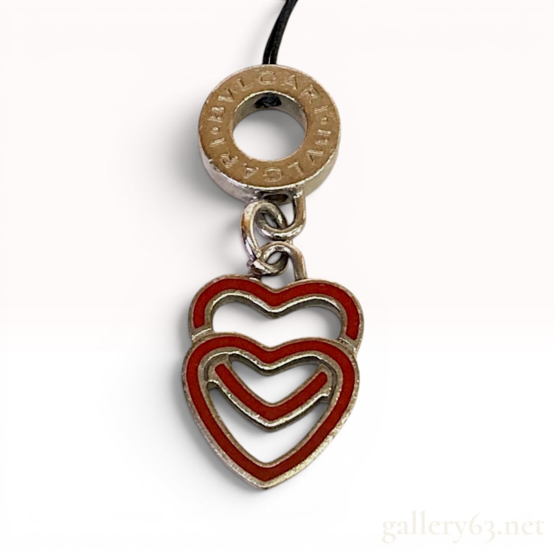 Bvlgari Silver-Toned and Red Enamel Interlocking Double Heart Charm: A designer bag charm by Bvlgari featuring an interlocking double heart motif. The piece is constructed from silver-toned metal with red enamel or resin inlay set into open-work heart frames. The penda