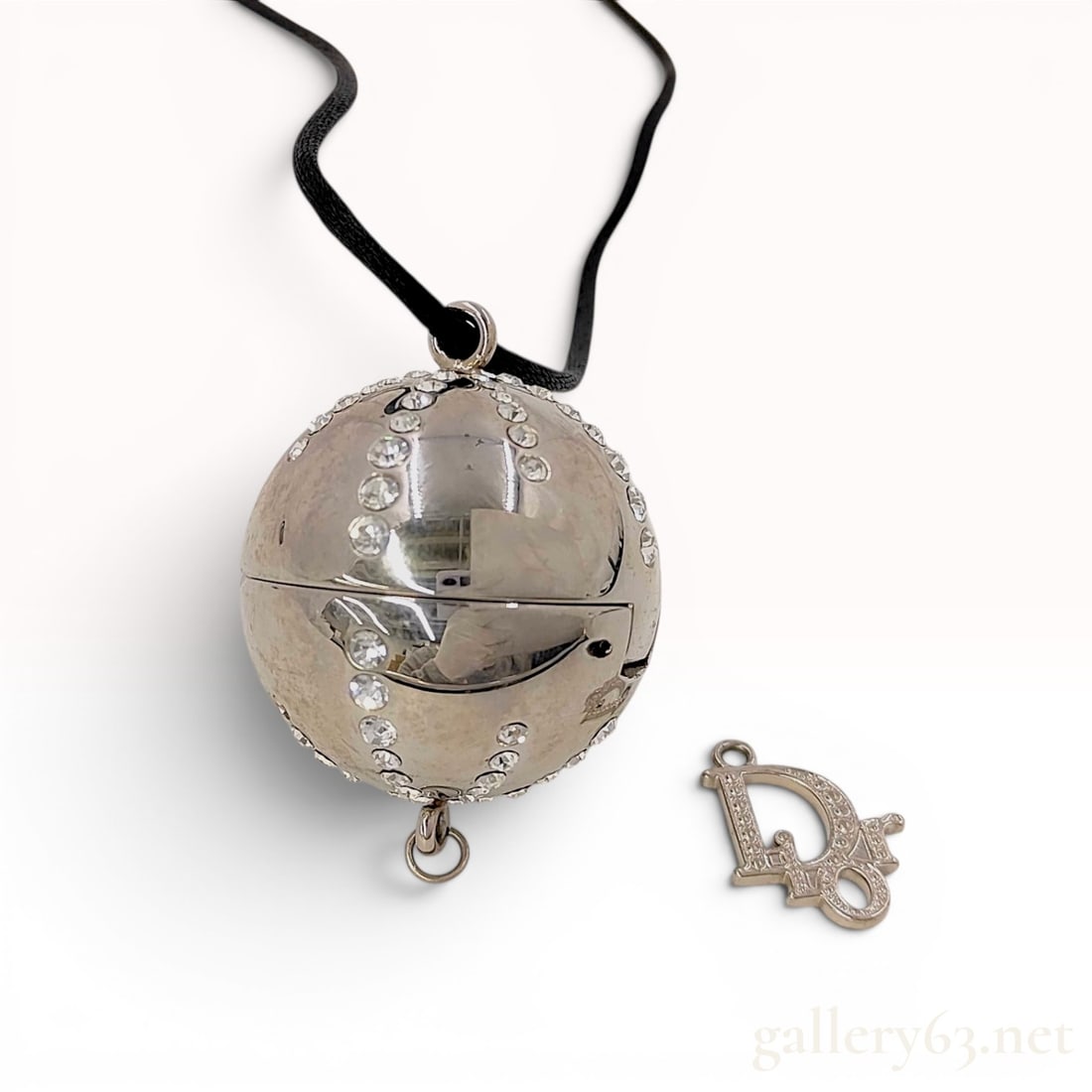 Parfums Christian Dior Vintage Rhinestone Spherical Locket Necklace and Logo Charm: A vintage Parfums Christian Dior spherical pomander-style locket pendant, marketed as a promotional item for cosmetics or fragrances. The silver-tone base metal sphere is embellished with round colorl