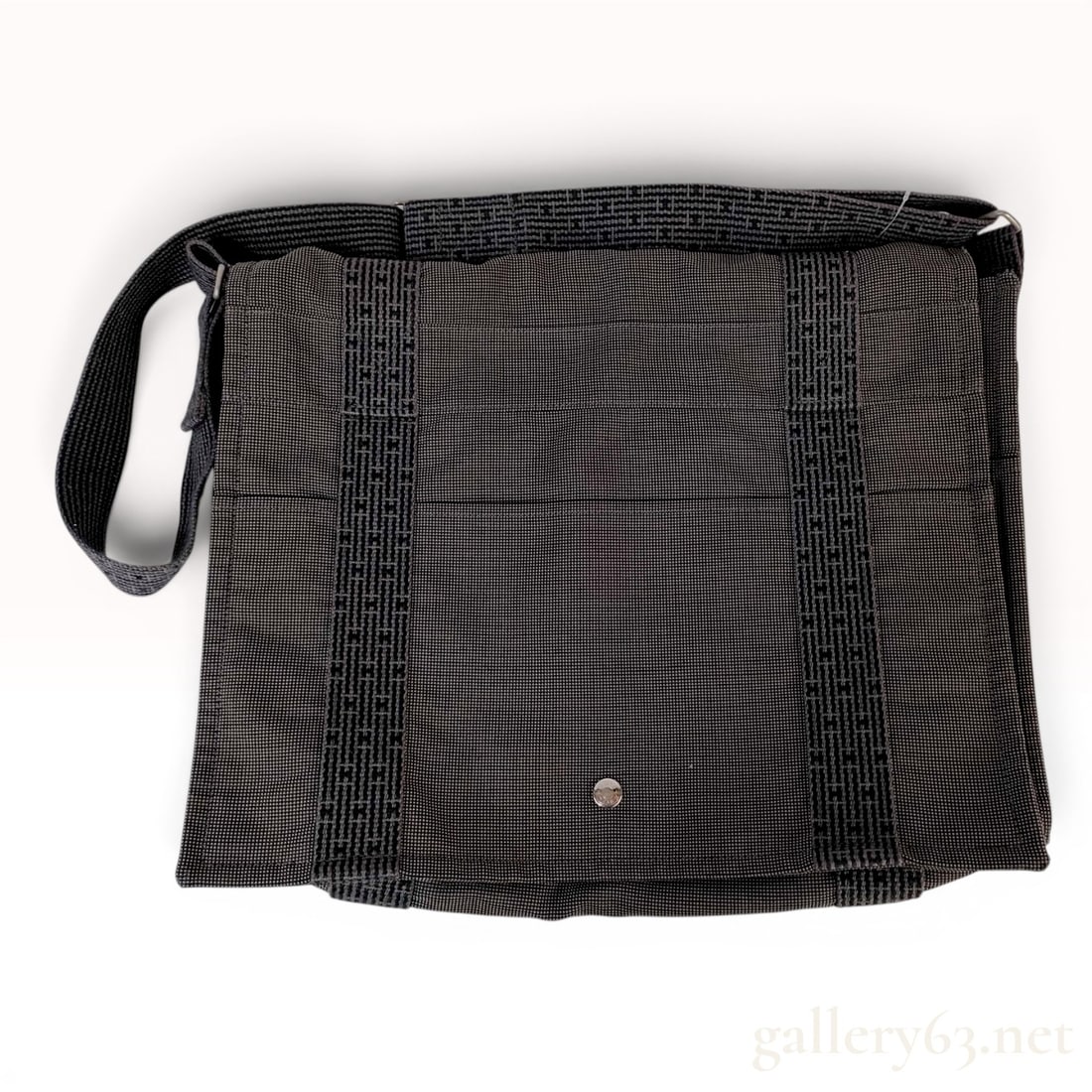 Hermes Herline Gray Canvas Messenger Bag: A messenger bag from the Hermes Herline collection, crafted from durable gray woven canvas with charcoal and black accents. The design features two vertical ribbons and a wide, adjustable shoulder str