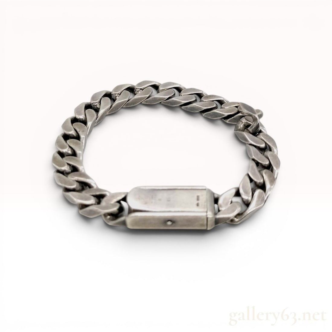 Gucci Sterling Silver Heavy Curb Link Bracelet: A heavy curb link bracelet by Gucci crafted in sterling silver. The piece consists of flat, interlocking links secured by a substantial rectangular box clasp with a push-button release. The interior o