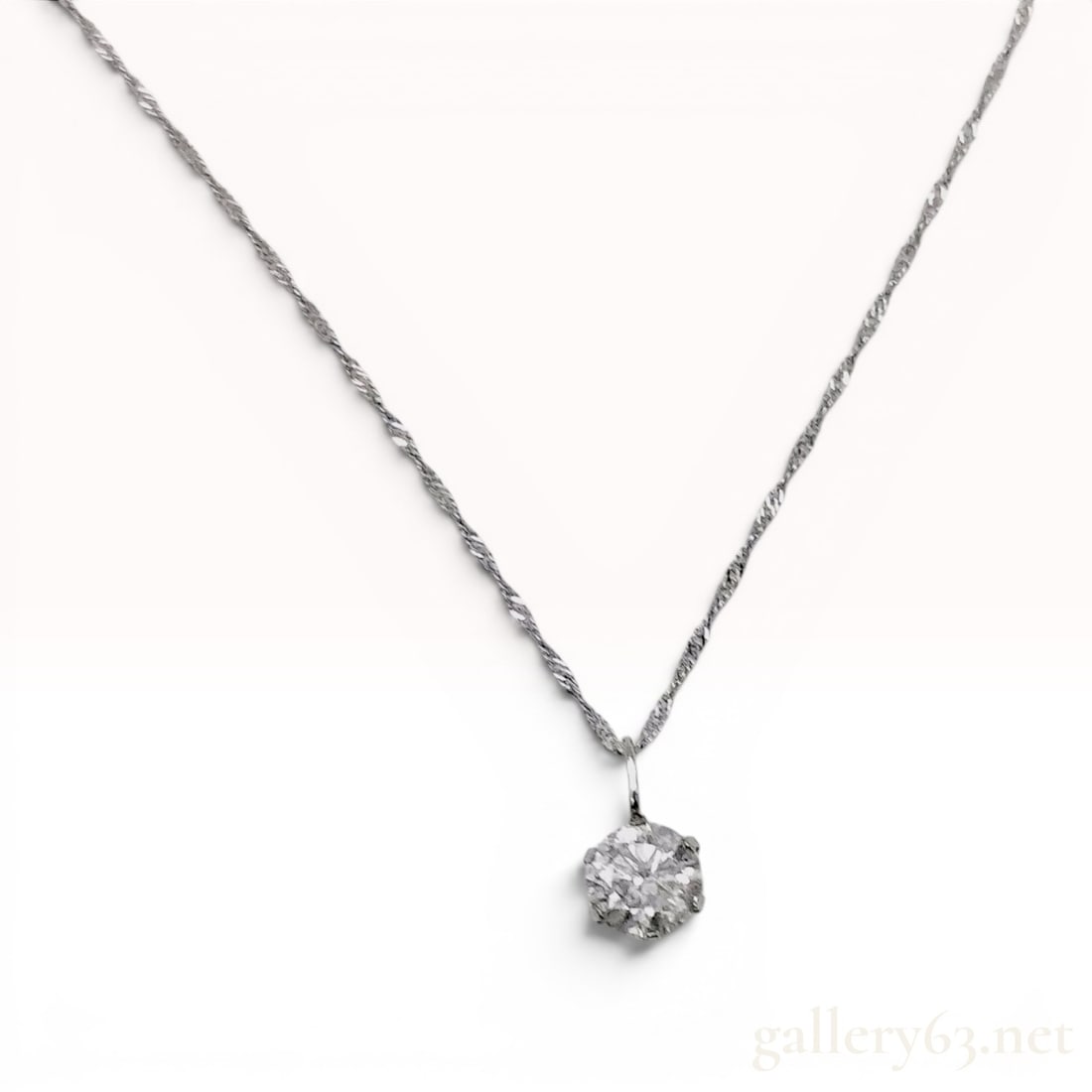 Platinum and 0.65ct Diamond Solitaire Pendant Necklace: This solitaire pendant necklace features a single round brilliant-cut diamond. The gemstone is secured within a traditional six-prong basket setting crafted from platinum. The pendant is suspended fro