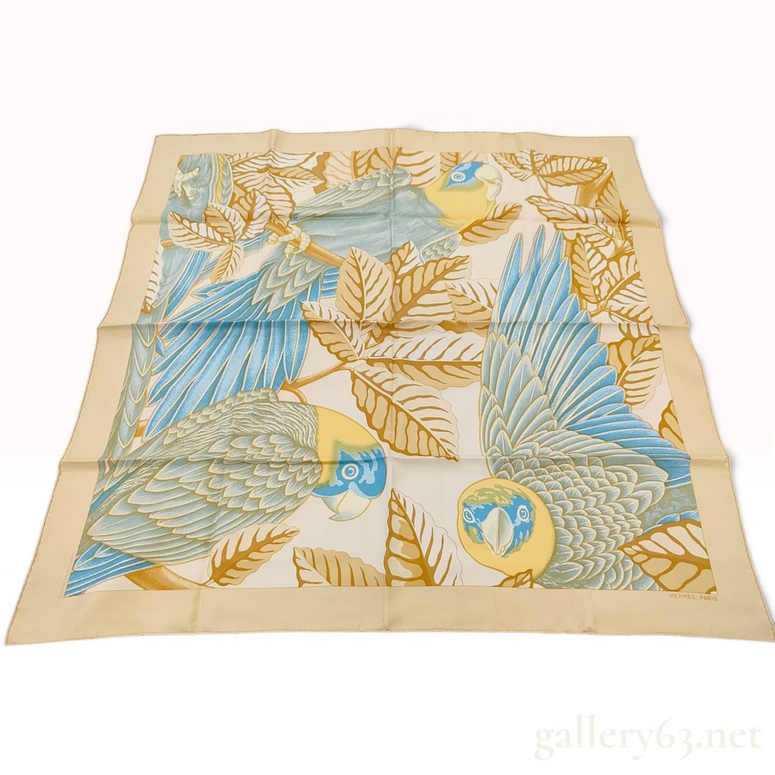 Hermes Les Perroquets Silk Twill Scarf: An Hermes silk twill scarf in the Les Perroquets pattern, designed by artist Joachim Metz. The motif features large-scale parrots perched among tropical foliage. The colorway consists of an ivory grou