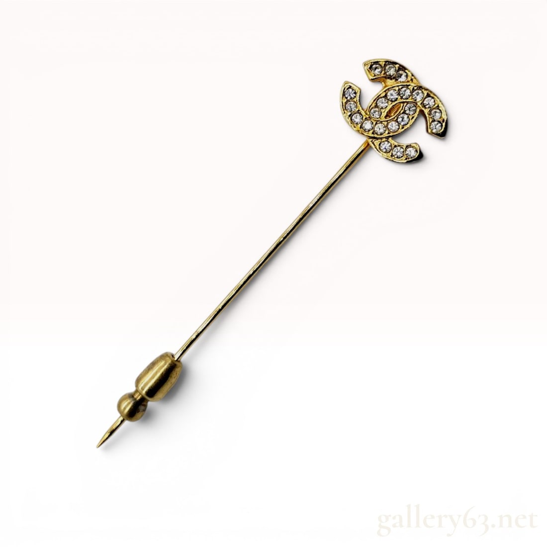Chanel Gold-Tone and Crystal Interlocking CC Logo Stick Pin: This designer stick pin features the signature Chanel interlocking CC logo motif. The logo is pave-set with colorless round-cut crystals and finished with a textured, hammered-effect reverse. The deco