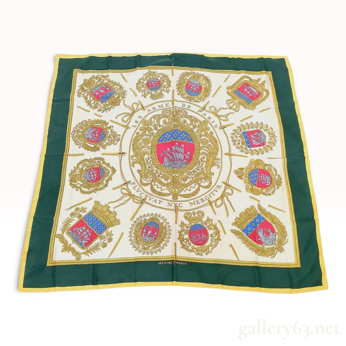 Hermes Silk Scarf in Les Armes de Paris Pattern by Hugo Grygkar: This is a square silk scarf featuring the Les Armes de Paris pattern, a design by Hugo Grygkar for Hermes. The layout consists of a large central coat of arms for Paris, featuring a ship and the