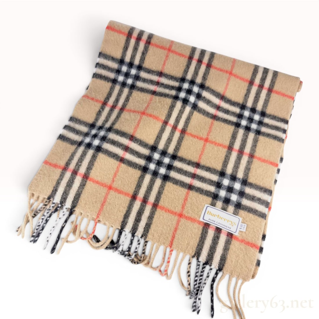 Vintage Burberrys Nova Check Pure Cashmere Scarf: This vintage Burberrys scarf is crafted from 100 percent pure cashmere and features the signature Burberry house check, known as the Nova Check, in a palette of camel, black, white, and red. The