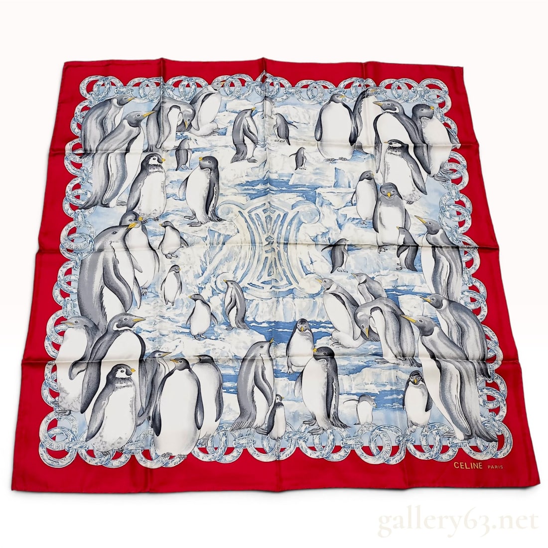 Celine Paris Silk Scarf with Penguin Motif and Red Border: This square scarf is crafted from 100 percent silk and features a detailed illustration of various penguins on a stylized ice and snow landscape. The center of the scarf displays a large, tonal