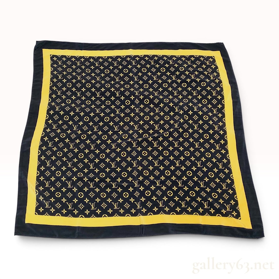 Louis Vuitton Monogram Silk Square Scarf: This square scarf by Louis Vuitton features the brand signature monogram pattern in yellow on a black ground. The all-over repeating design consists of interlocking LV initials interspersed with four-