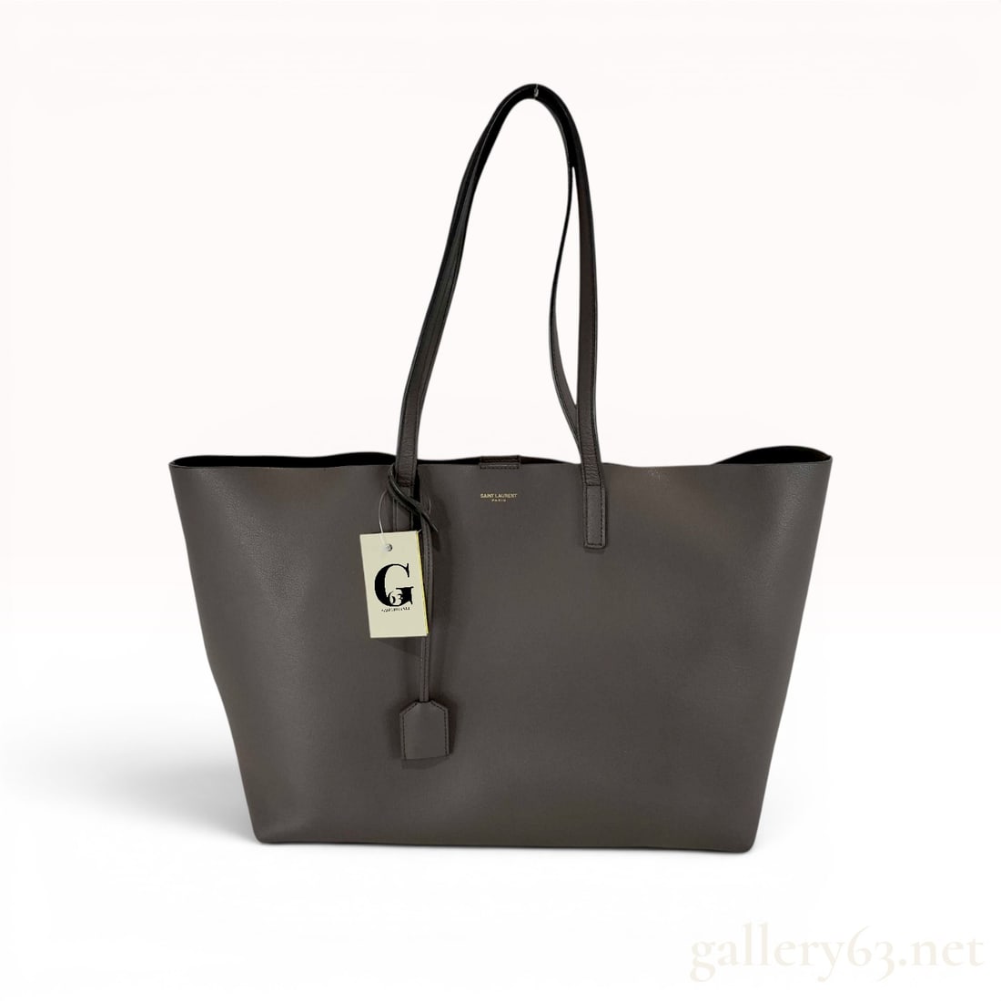 Saint Laurent Grey Grained Leather Shopping Tote: This Saint Laurent Shopping Tote is crafted from grey grained calfskin leather and features gold-tone hardware. The exterior is detailed with dual flat leather shoulder straps and the designer logo in