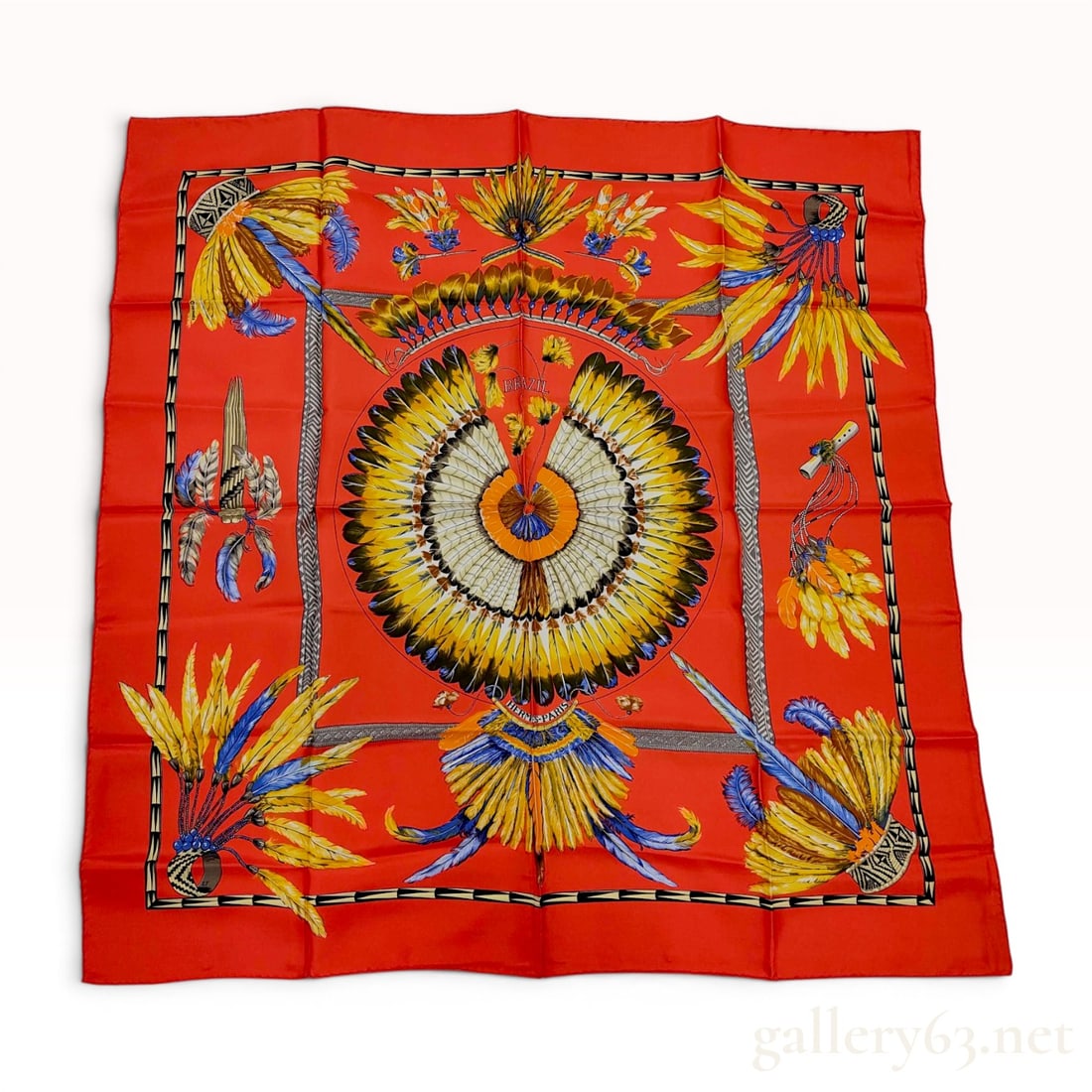 Hermes Brazil Silk Scarf designed by Laurence Bourthoumieux: This Hermes silk scarf features the Brazil pattern, originally designed by Laurence Bourthoumieux under the pseudonym Loïc Dubigeon in 1988. The design is set against a vibrant red ground and dep