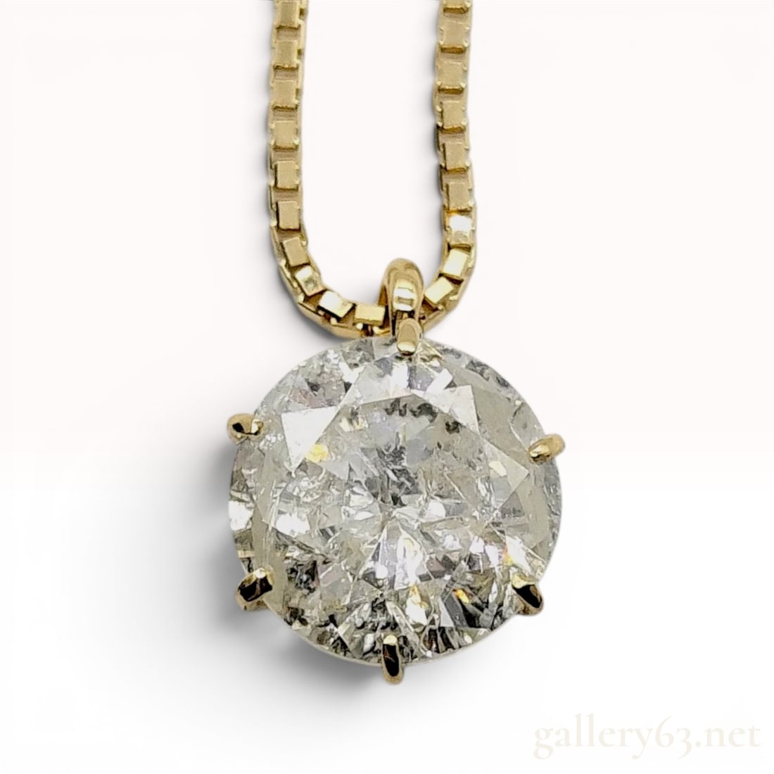1.25 Carat Round Brilliant Cut Diamond Solitaire Pendant Necklace in 18K Yellow Gold: A diamond solitaire pendant necklace featuring one round brilliant cut diamond weighing 1.25 carats. The diamond is secured in a six-prong 18-karat yellow gold basket mounting. The pendant is suspende