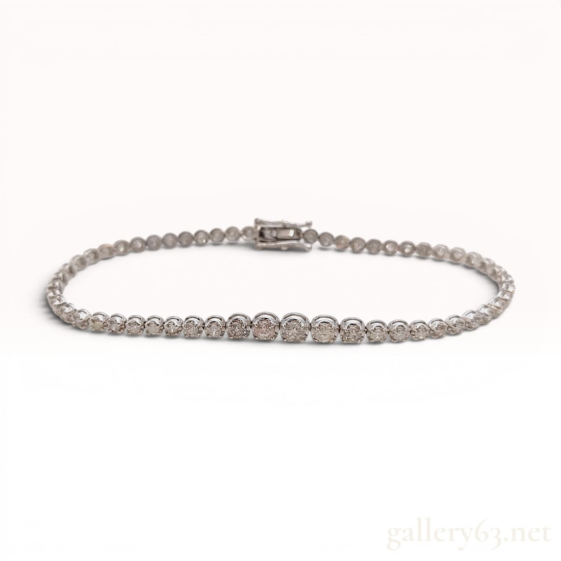 18 Karat White Gold and 2.00 Carat Diamond Tennis Bracelet: This tennis bracelet is crafted in 18 karat white gold and features a continuous line of round brilliant-cut diamonds. Each diamond is individually set in a four-prong circular mount, connected by