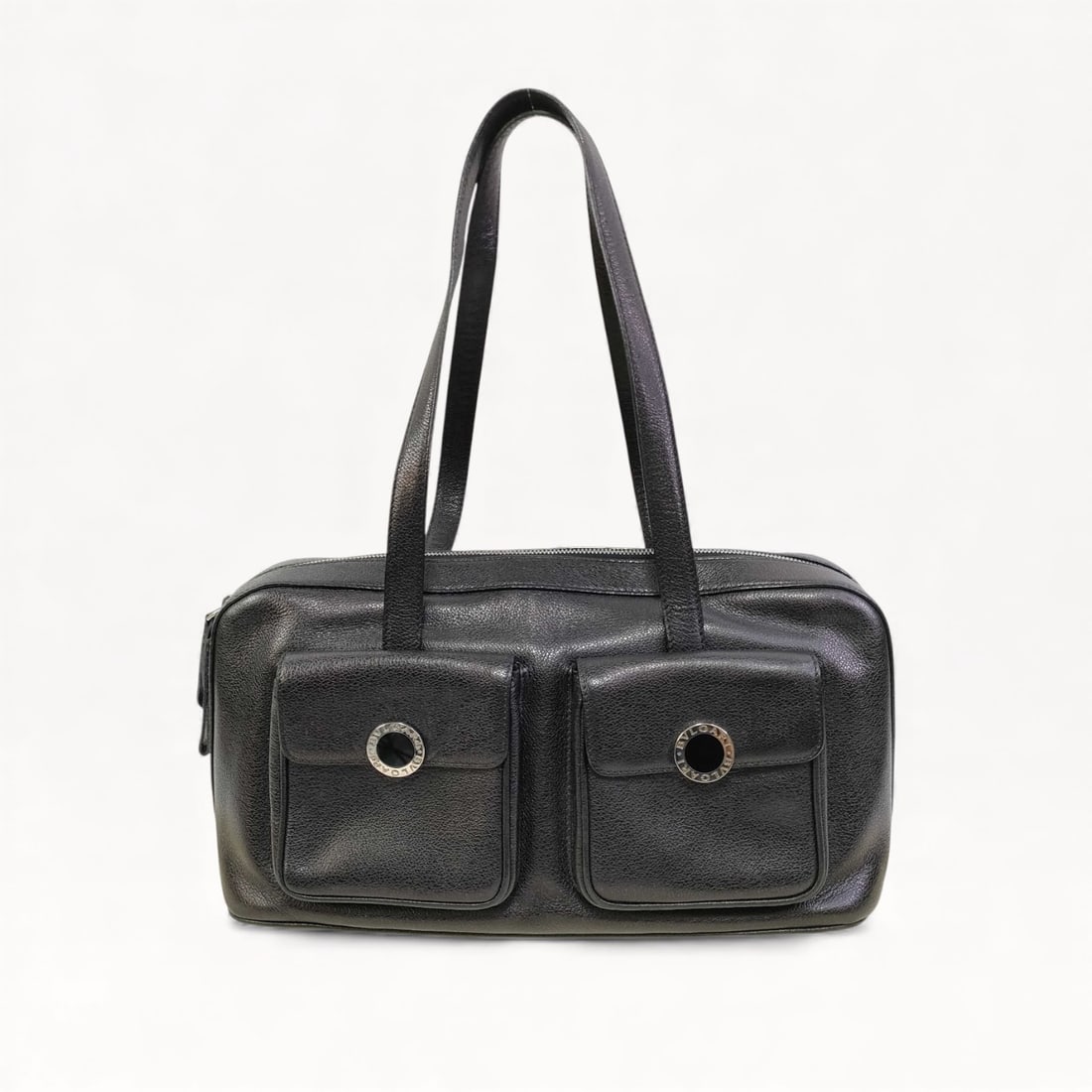 Bulgari Black Grained Leather Twin Pocket Shoulder Bag: Bulgari shoulder bag in black pebbled calfskin leather. Features dual front flap pockets with silver-tone circular hardware and a top zipper closure. The bag is finished with dual flat leather shoulde