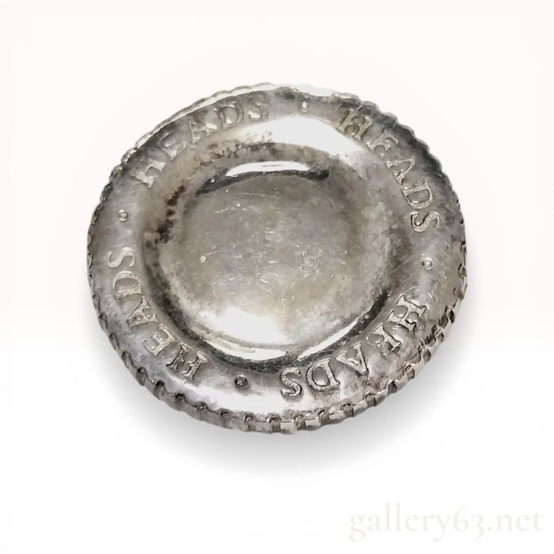 Tiffany and Co. Sterling Silver Heads or Tails Decision Token, 2005: Tiffany and Co. sterling silver decision token, dated 2005. The coin features a concave obverse with a raised rim incised with the word HEADS repeated four times and a convex reverse stamped with TAIL