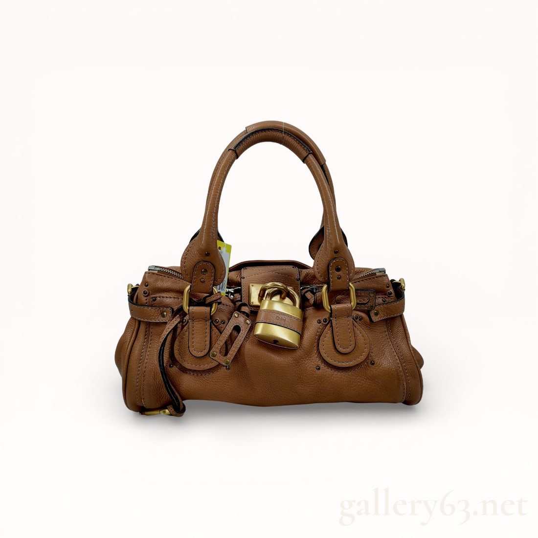 Chloe Paddington Grained Leather Satchel in Tan: Chloe Paddington satchel crafted from tan pebbled calfskin leather, mid-2000s. The slouchy silhouette features dual rolled top handles with oversized ring attachments, functional side buckles, and sig