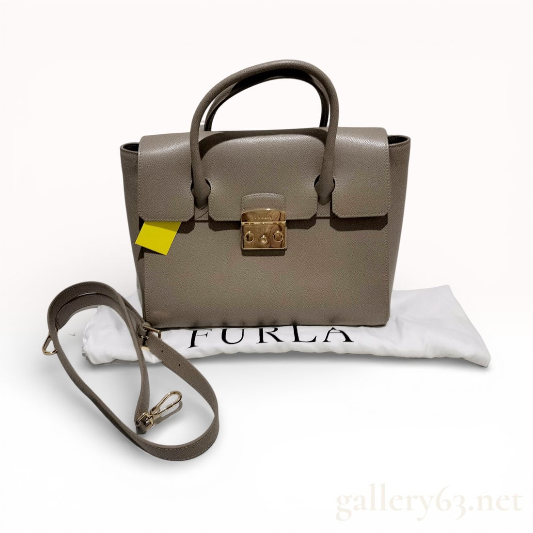 A Furla Metropolis Leather Medium Satchel: A Furla Metropolis medium satchel crafted from taupe-colored textured leather with gold-tone hardware. The bag features a front flap secured by a signature push-lock clasp, dual rolled top handles, an