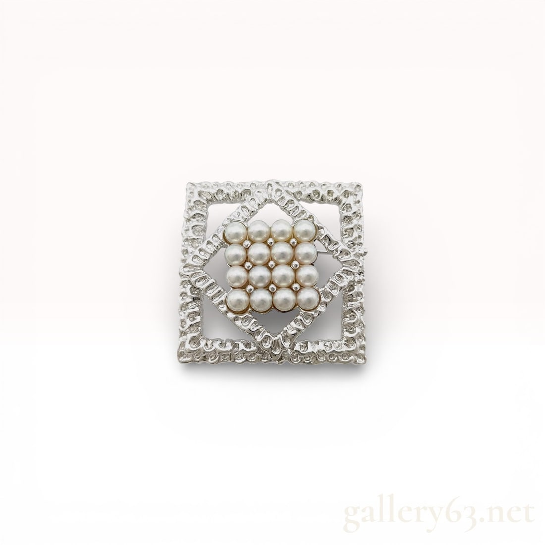 Sterling Silver and Pearl Geometric Openwork Brooch: Sterling silver and pearl geometric brooch, late 20th century. The openwork design features a central grid of sixteen white pearls within nested diamond and square frames with a textured nugget finish