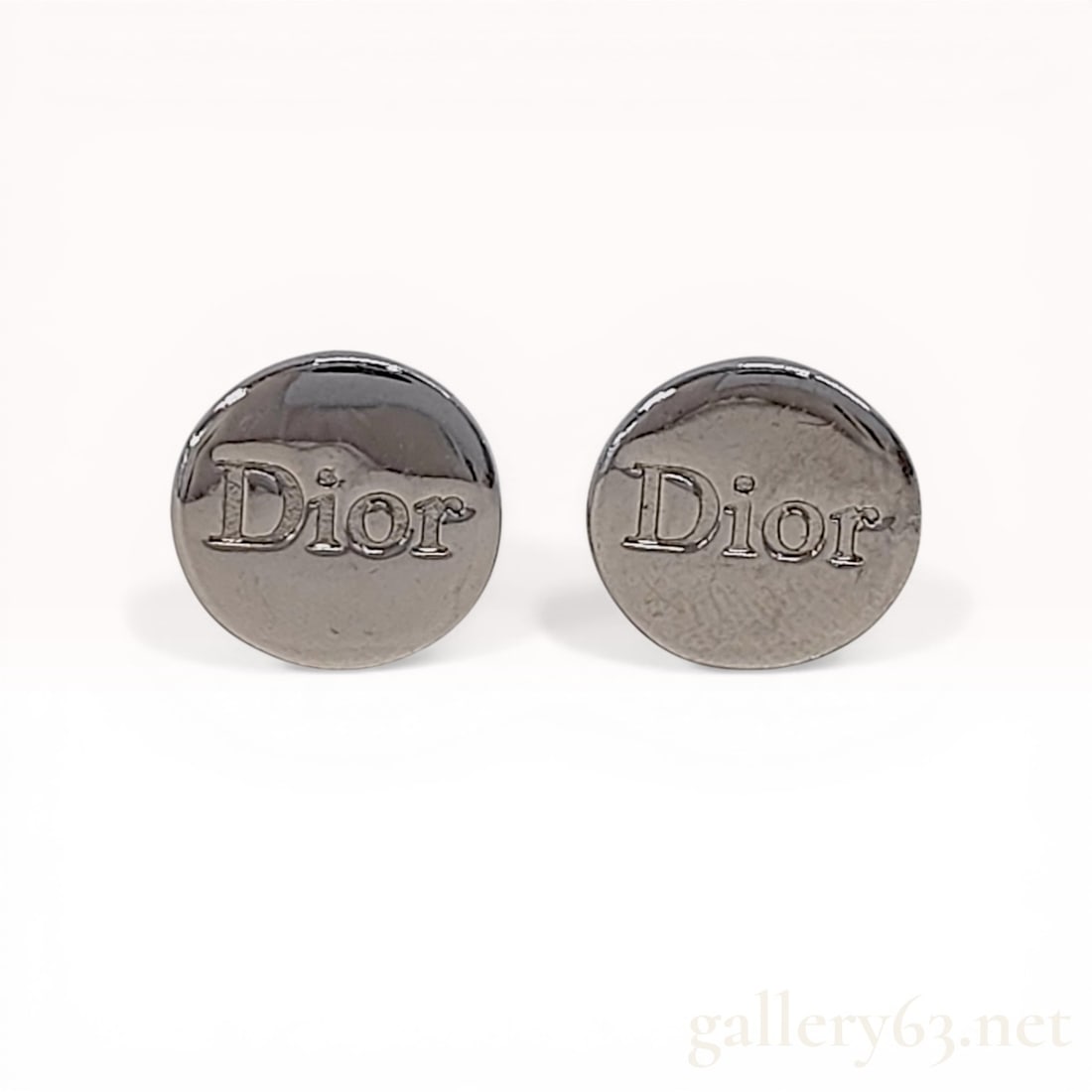A Pair of Christian Dior Silver-Tone Logo Clip-On Earrings: Christian Dior circular logo earrings, late 20th century. Crafted from silver-tone metal, each earring features an embossed serif Dior logo on a polished circular face. The reverse features lever clip