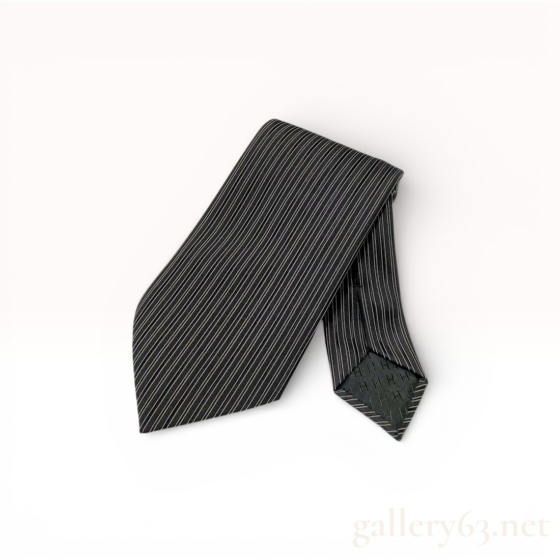 Hermes Silk Pinstripe Necktie: Hermes silk necktie featuring a pattern of fine horizontal pinstripes in white and light grey on a black ground. The accessory is constructed from 100 percent silk and includes a tonal black silk jacq