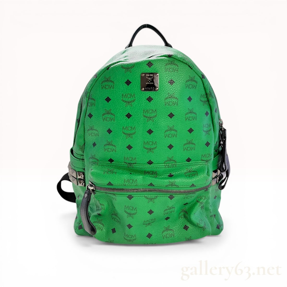 MCM Visetos Large Stark Backpack in Green: MCM Stark backpack in green Visetos monogrammed coated canvas with black leather trim and gunmetal-tone hardware. The exterior features a front zippered pocket, two side slip pockets with pyramid stud